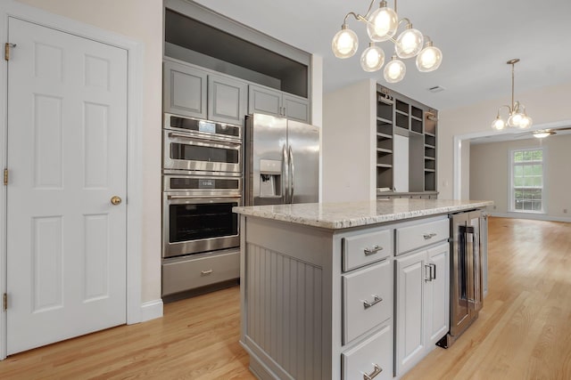 332 Winnstead Ct, Tallahassee, FL 32312 - kitchen featuring a chandelier, beverage cooler, light wood-type flooring, and appliances with stainless steel finishes