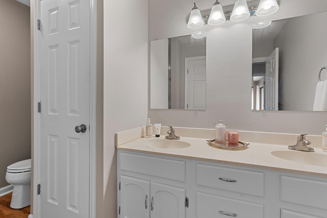 bathroom with hardwood / wood-style floors, vanity, and toilet