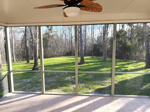 unfurnished sunroom featuring ceiling fan and a wealth of natural light