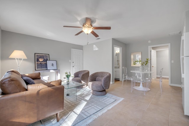 living area with ceiling fan, light tile patterned flooring, visible vents, and baseboards