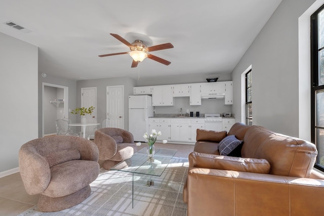 living area with ceiling fan, visible vents, and baseboards