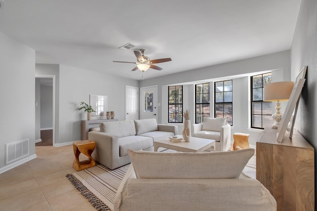 living area with a ceiling fan, visible vents, baseboards, and light tile patterned floors