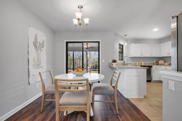 dining space featuring baseboards, a notable chandelier, and wood finished floors