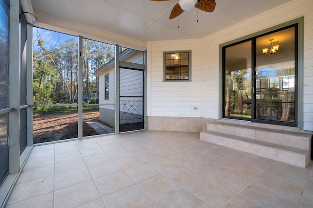 unfurnished sunroom featuring a ceiling fan