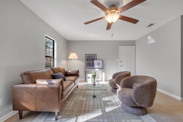 living room with a ceiling fan, visible vents, and baseboards