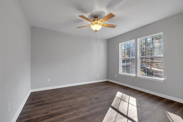 spare room with dark wood-style flooring, ceiling fan, and baseboards