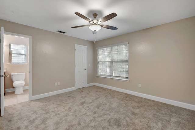 unfurnished bedroom featuring baseboards, multiple windows, visible vents, and light colored carpet