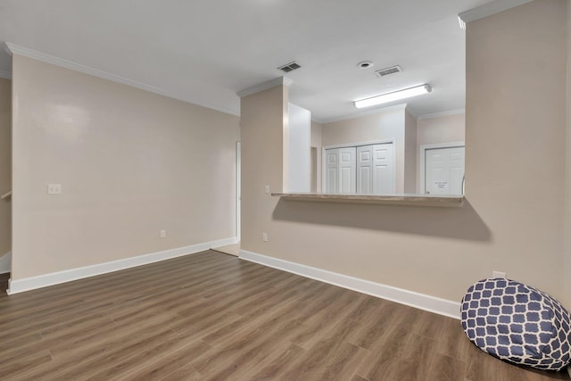 unfurnished room featuring baseboards, visible vents, dark wood-type flooring, and crown molding