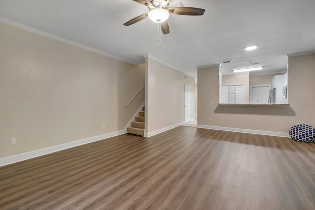 unfurnished living room with crown molding, baseboards, and wood finished floors