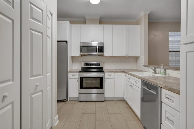 kitchen featuring light countertops, appliances with stainless steel finishes, a sink, and white cabinets