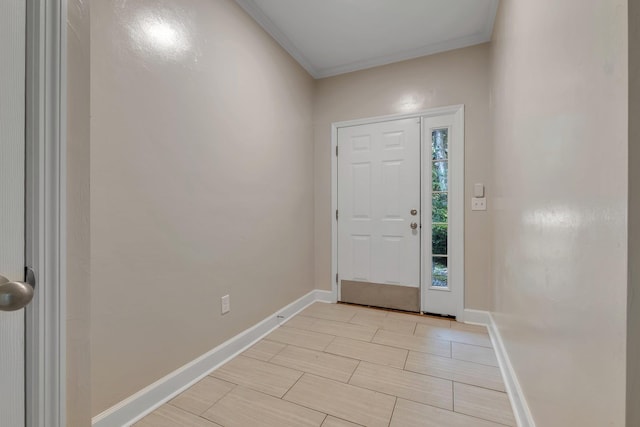 foyer with ornamental molding and baseboards