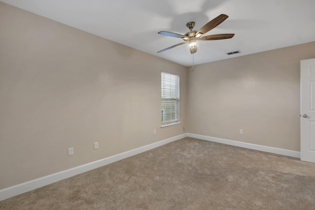 empty room with a ceiling fan, visible vents, light carpet, and baseboards