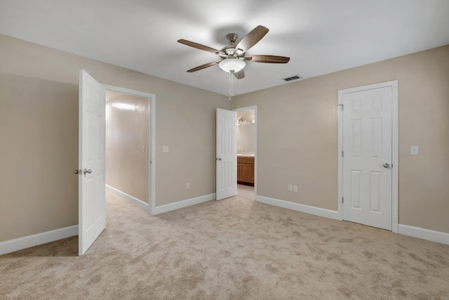 unfurnished bedroom with ceiling fan, connected bathroom, light colored carpet, visible vents, and baseboards