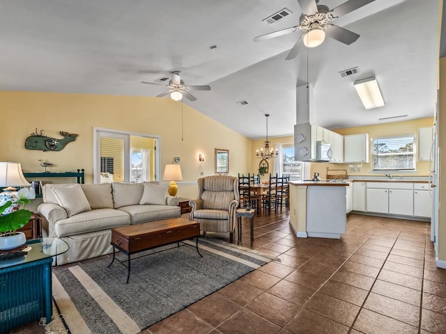 tiled living room with vaulted ceiling and ceiling fan with notable chandelier