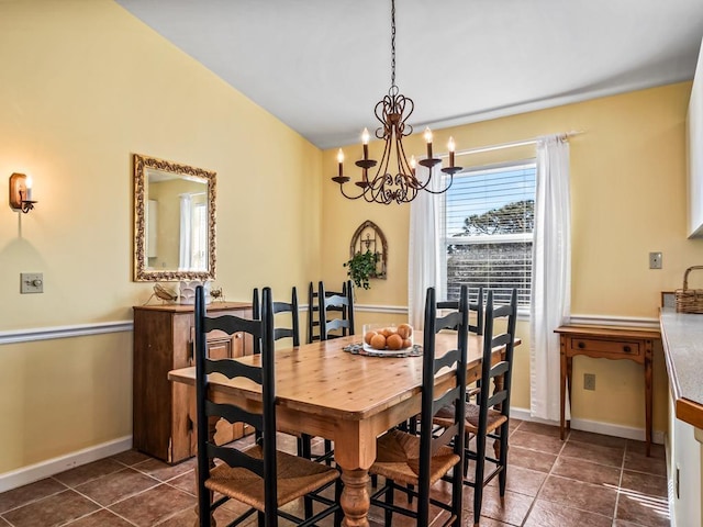 dining area featuring a notable chandelier and dark tile patterned floors