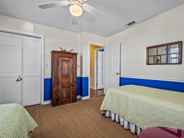 bedroom featuring a closet, ceiling fan, and dark colored carpet