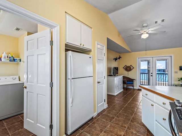 kitchen featuring vaulted ceiling, white cabinetry, washer / dryer, white refrigerator, and french doors