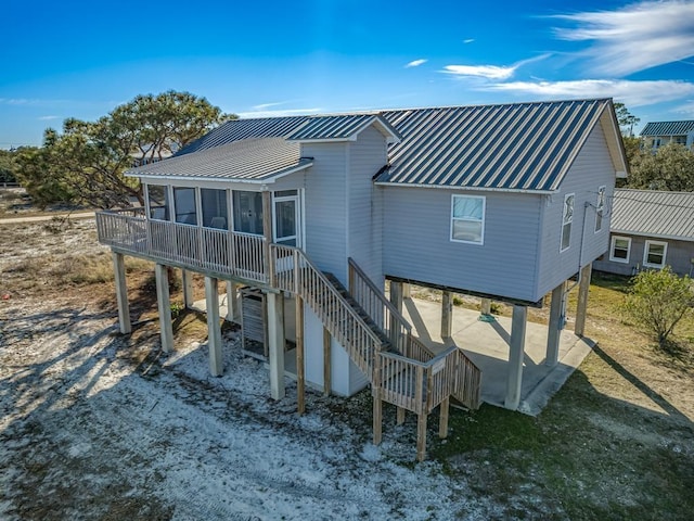 back of property with a carport and a sunroom