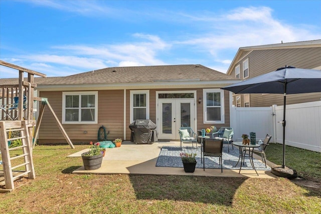 rear view of property featuring outdoor lounge area, a yard, a patio, and french doors