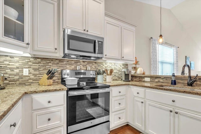 kitchen with tasteful backsplash, stainless steel appliances, sink, pendant lighting, and white cabinets