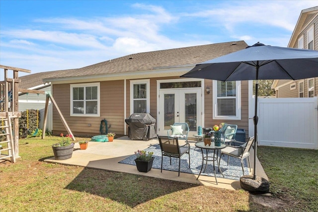 back of property with an outdoor living space, a yard, a patio, and french doors