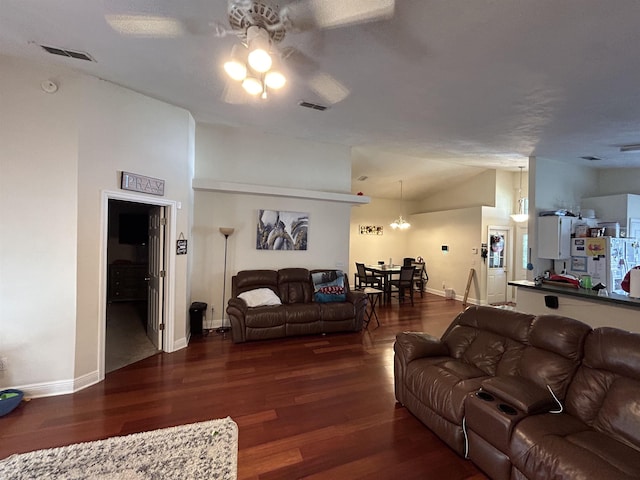 living room featuring dark wood-type flooring, ceiling fan, and vaulted ceiling