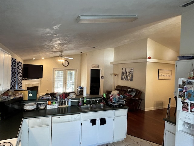 kitchen featuring white cabinetry, white appliances, lofted ceiling, and sink