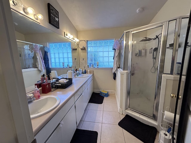 bathroom featuring lofted ceiling, vanity, tile patterned flooring, and walk in shower