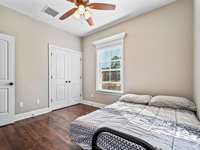 bedroom with ceiling fan, dark hardwood / wood-style flooring, and a closet