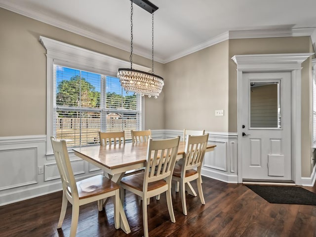 dining space with crown molding, dark wood-type flooring, and an inviting chandelier