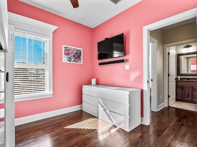 bedroom with connected bathroom, dark hardwood / wood-style floors, and ceiling fan