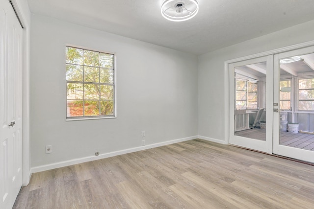 spare room featuring light wood-type flooring and french doors