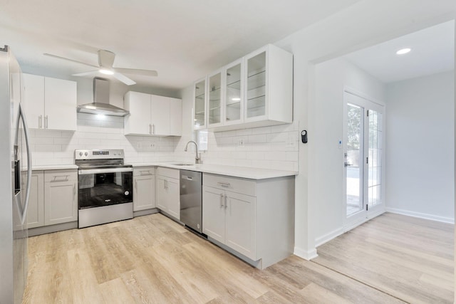 kitchen featuring white cabinets, sink, wall chimney exhaust hood, and appliances with stainless steel finishes