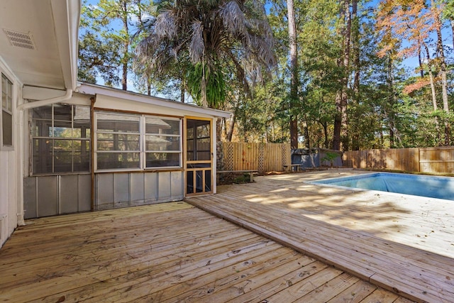 view of swimming pool featuring a deck and a sunroom