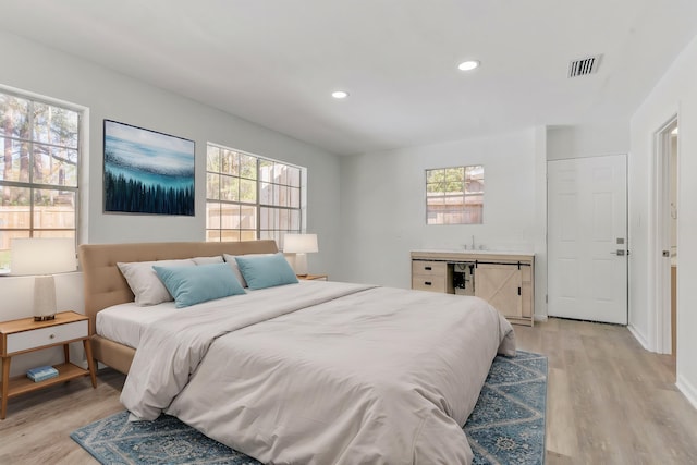 bedroom featuring multiple windows and light hardwood / wood-style floors