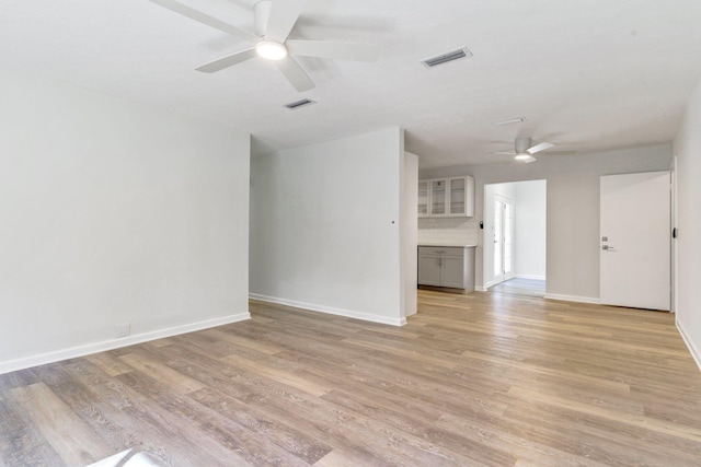 unfurnished living room featuring ceiling fan and light hardwood / wood-style flooring