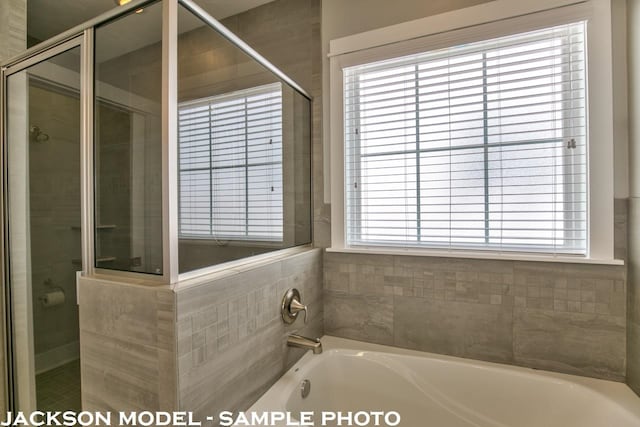 bathroom featuring independent shower and bath