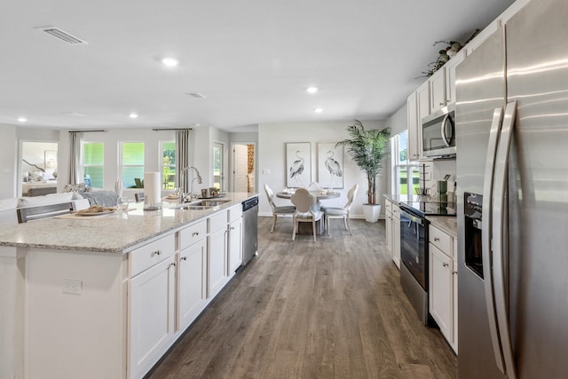 kitchen with white cabinetry, sink, a kitchen island with sink, and appliances with stainless steel finishes