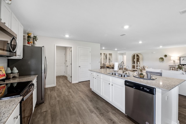 kitchen featuring stainless steel appliances, white cabinetry, sink, dark wood-type flooring, and a kitchen island with sink