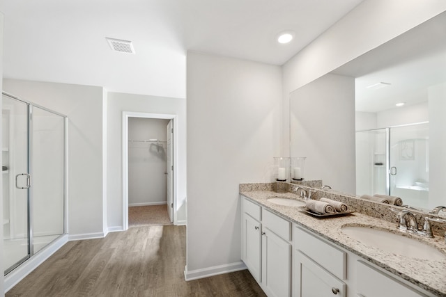 bathroom with walk in shower, hardwood / wood-style floors, and vanity