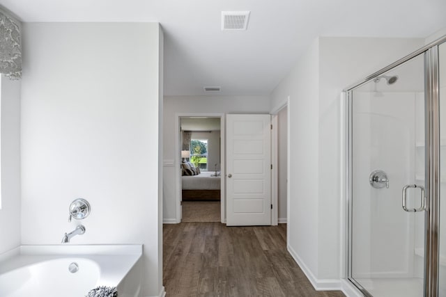 bathroom featuring shower with separate bathtub and wood-type flooring