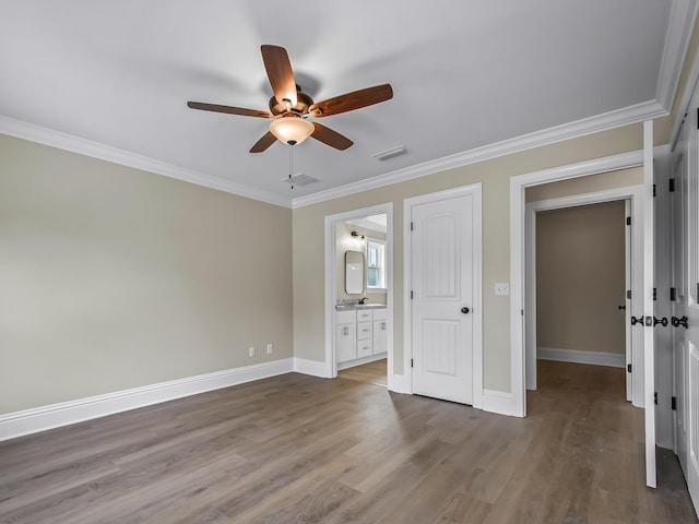 unfurnished bedroom featuring ceiling fan, ornamental molding, dark hardwood / wood-style flooring, and ensuite bath