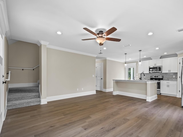 unfurnished living room featuring ceiling fan, dark hardwood / wood-style flooring, and ornamental molding