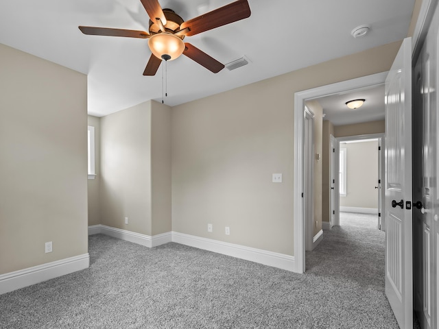 unfurnished room with ceiling fan and carpet