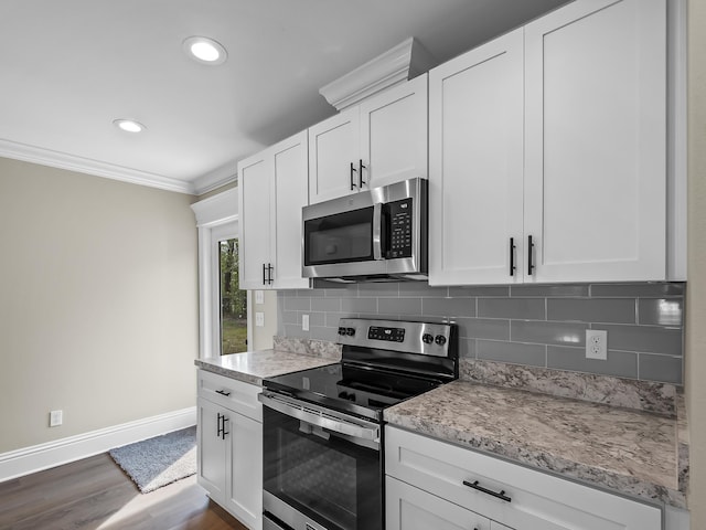 kitchen with dark wood-type flooring, backsplash, white cabinets, and stainless steel appliances