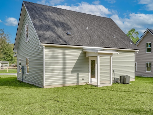 back of property featuring central AC unit and a lawn