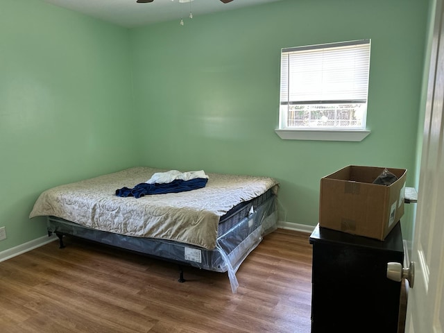 bedroom featuring ceiling fan, wood finished floors, and baseboards