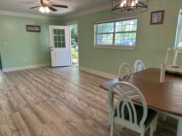 dining area with crown molding, baseboards, wood finished floors, and ceiling fan with notable chandelier