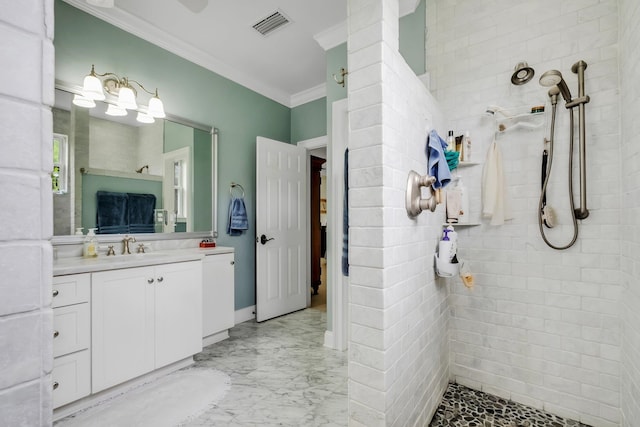 bathroom with ornamental molding, vanity, and tiled shower