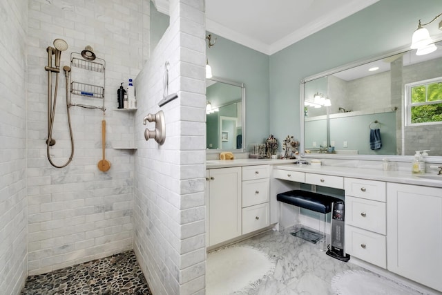 bathroom with vanity, a tile shower, and crown molding